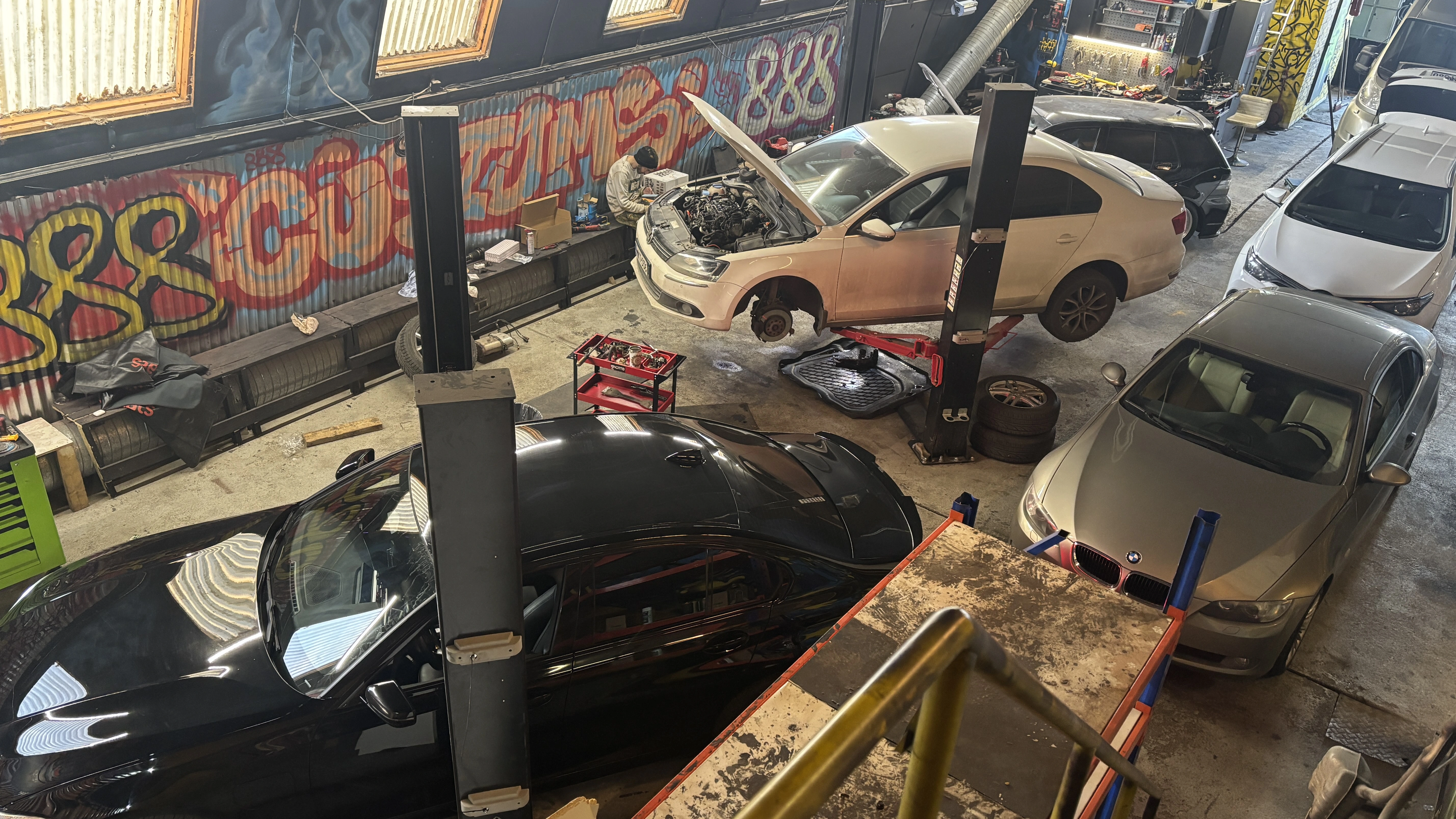 Mekaanikot työskentelemässä nosto-liftin alla