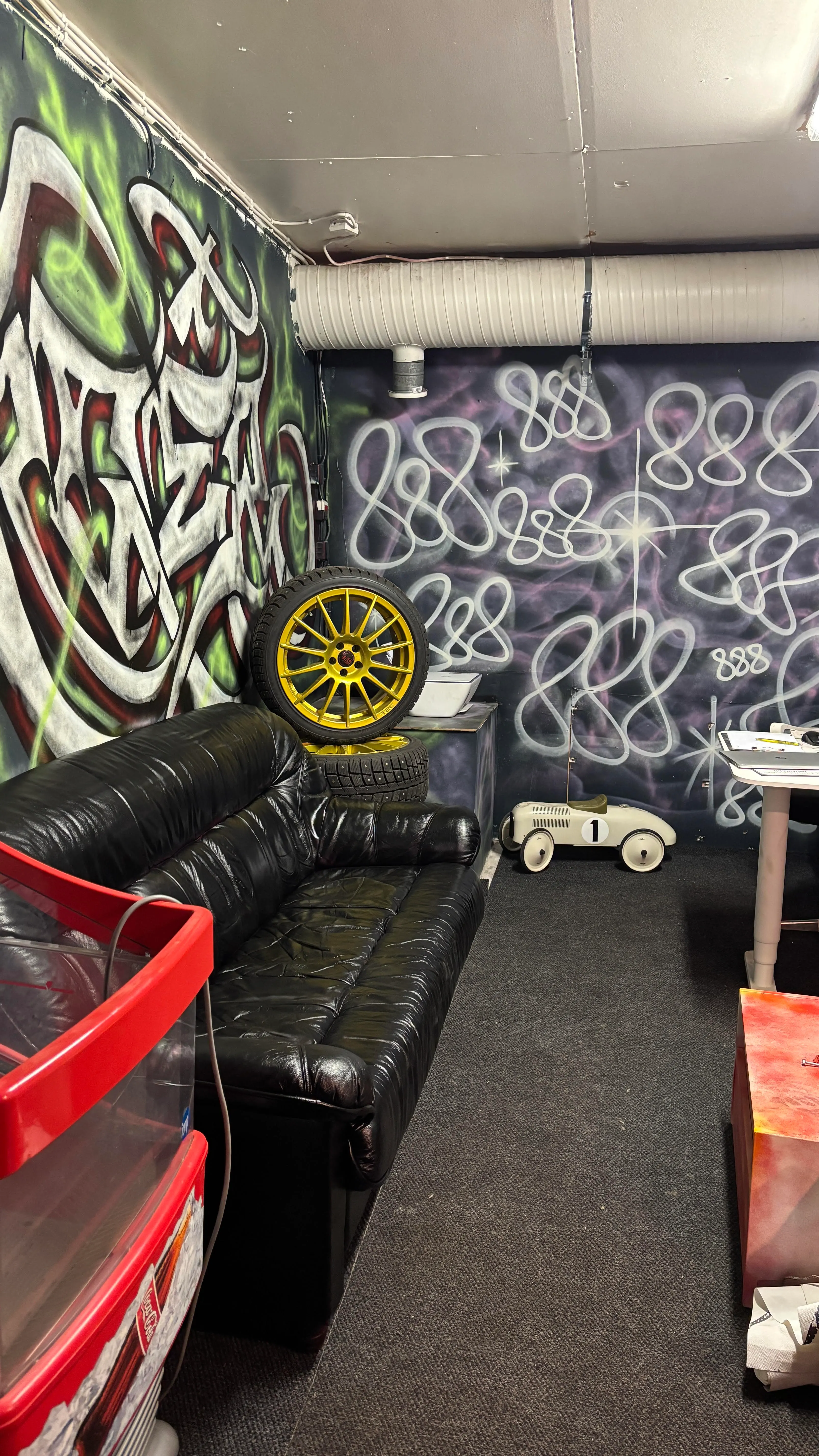 Odotustila — musta nahkasohva ja keltainen vannekiekko